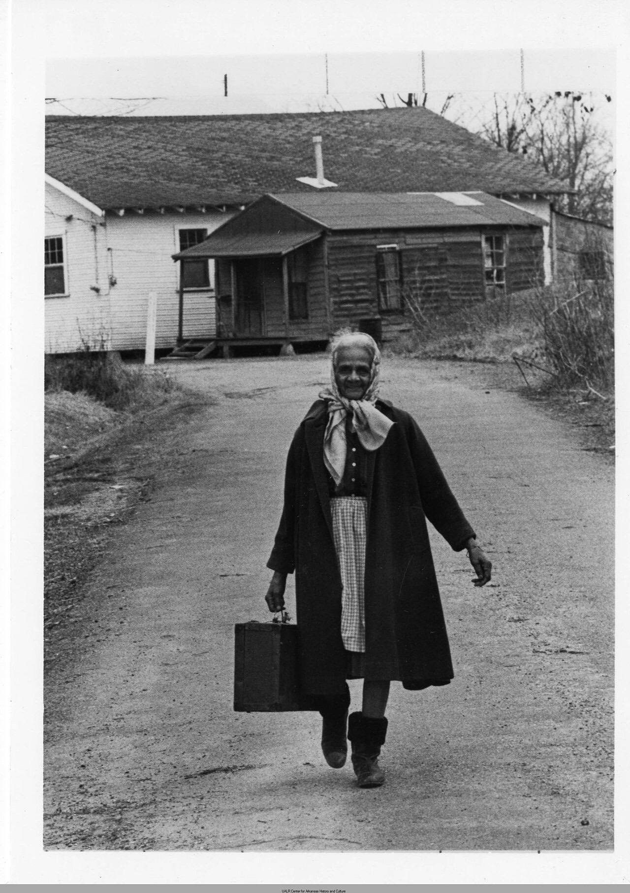 Bennie "Mama" McGuire walks down the street with her bag. She is a native of Marked Tree and a midwife since 1916.