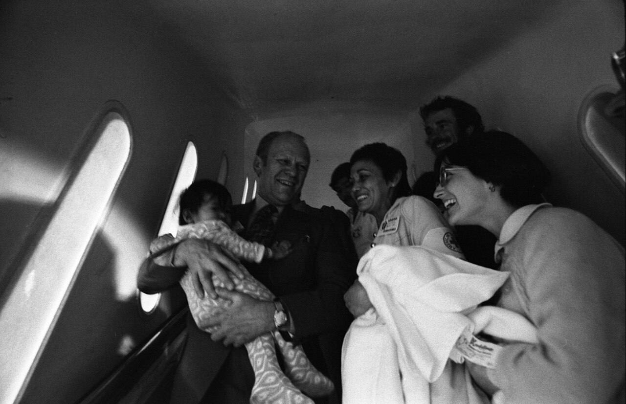 President Gerald R. Ford Holding a Refugee Baby and Talking with Nurses on an Operation Babylift Plane After Its Arrival at San Francisco International Airport