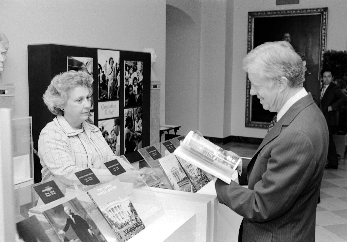 Jimmy Carter at White House Visitors Desk Looking at Guide Books
