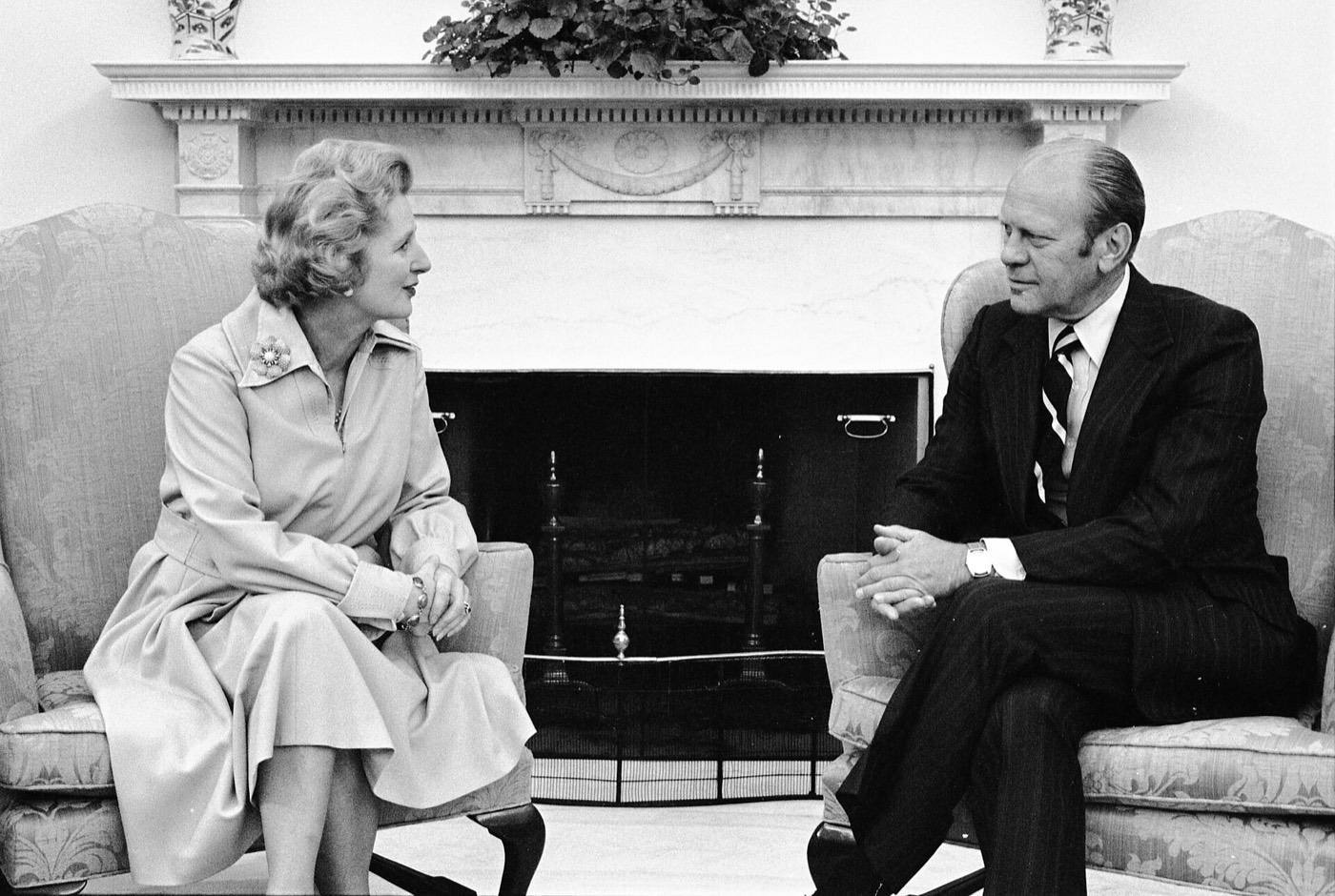 Gerald R. Ford, Margaret Thatcher - seated, talking near fireplace.