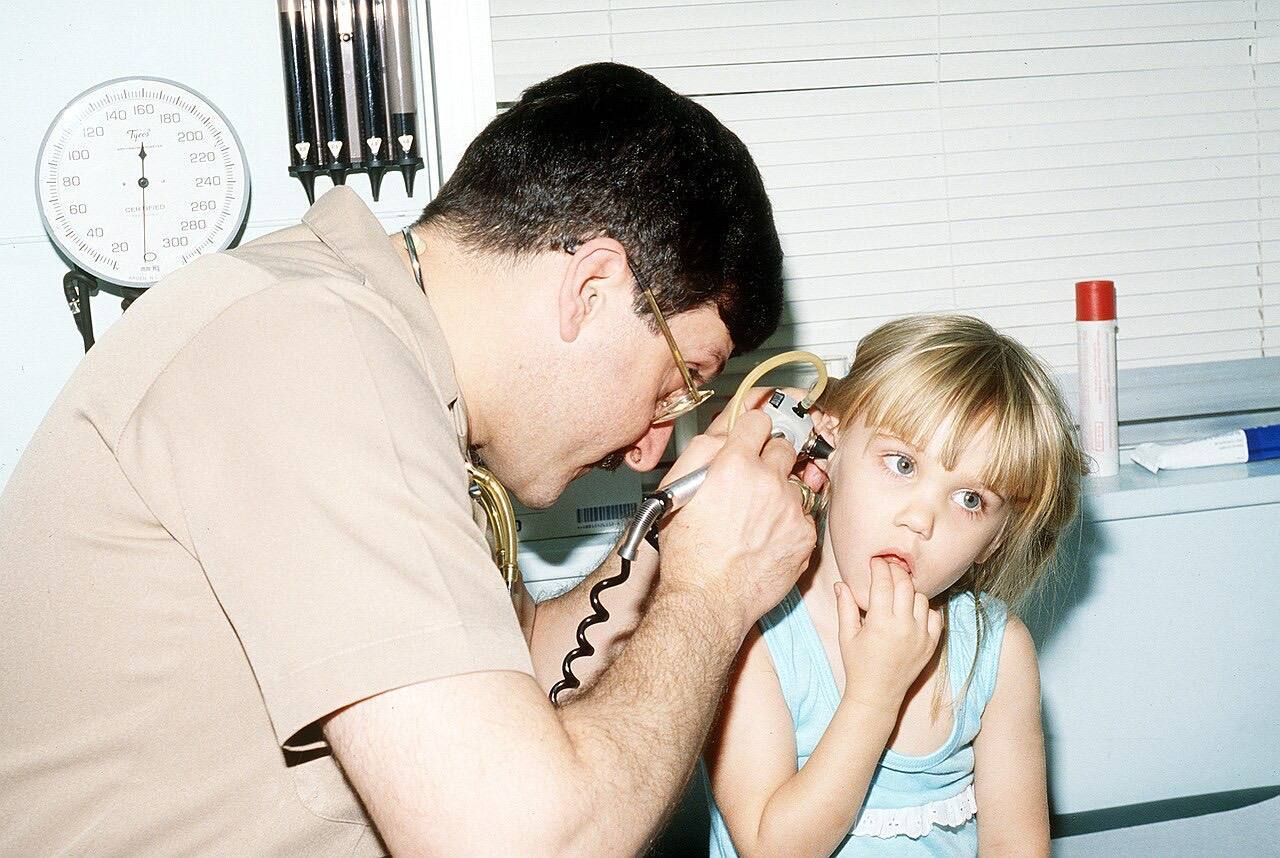 CMDR. Cooper checks a patient for a possible ear infection at the naval hospital's pediatrics clinic