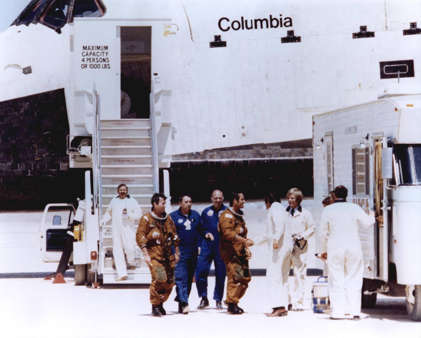 Space Shuttle astronauts John Young and Robert Crippen (in tan space suits) are greeted by members of the ground crew after stepping off the Space Shuttle Colum