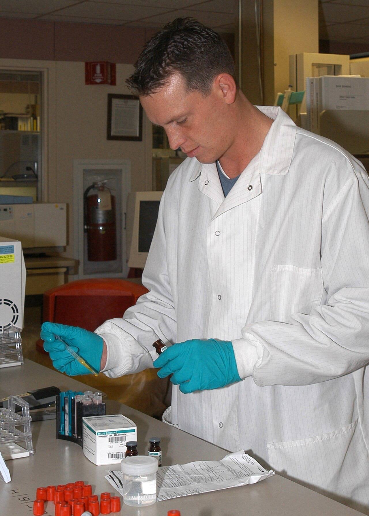 US Navy 030905-N-5956C-002 Hospital Corpsman 2nd Class Andrey Phibbs, prepares chemistry to calibrate the chemistry analyzer machine