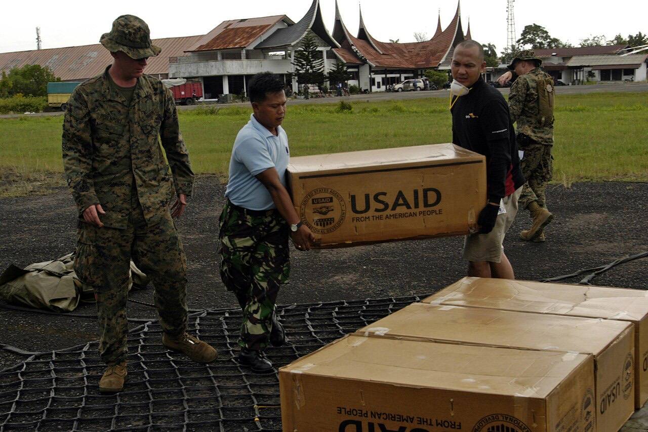 US Navy 091012-N-4917P-059 Workers load a cargo net of supplies from The United States Agency for International Development (USAID)