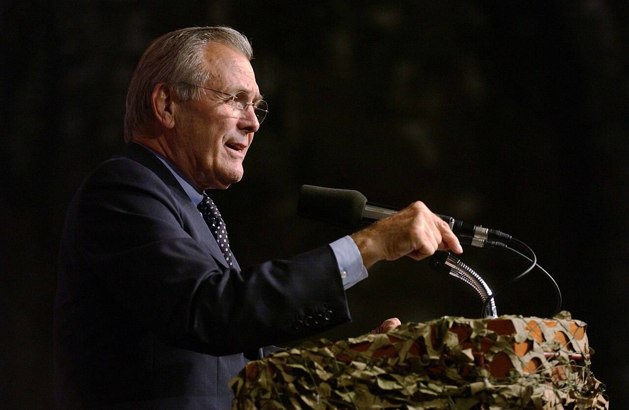 The Honorable Donald H. Rumsfeld (standing at the lectern), U.S. Secretary of Defense, answers questions during a Town Hall meeting being conducted in the Colli