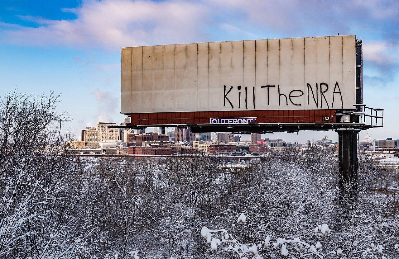 A billboard in front of the Saint Paul, Minnesota skyline is graffitied with "Kill The NRA" (National Rifle Association). 25 Feb 2018.