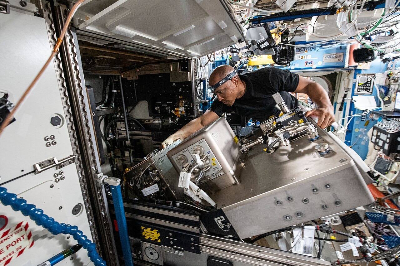 Victor Glover works on ISS machinery